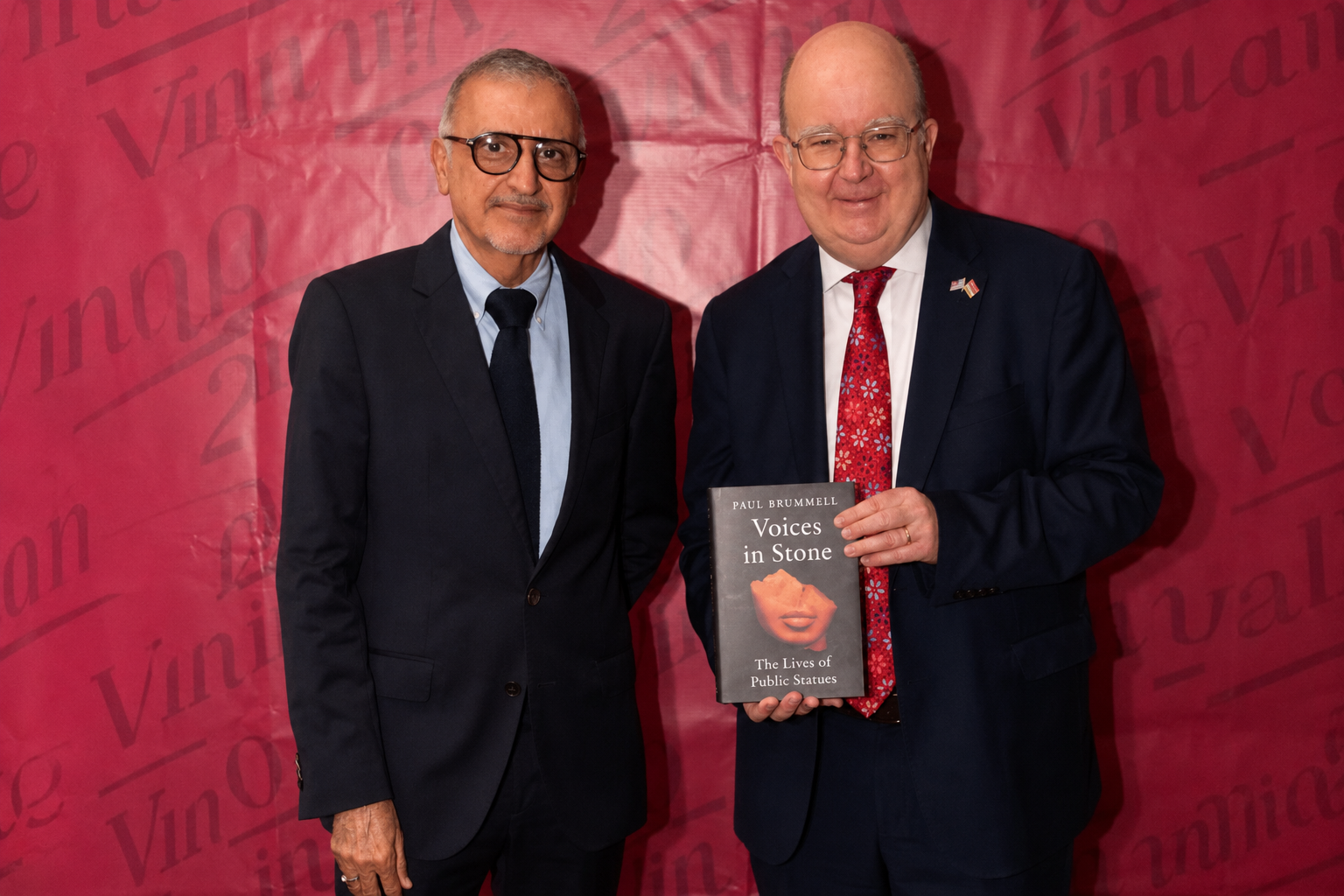 Members posing with the book 'Voices in Stone' at a book launch event